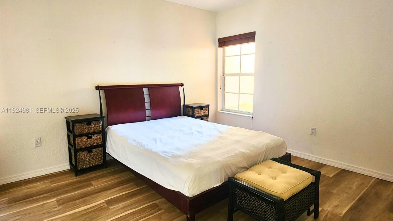 2557 Centergate Drive, Unit 101 Miramar, FL 33025 - Photo 14 of 14 a bed sitting in a bedroom next to a window