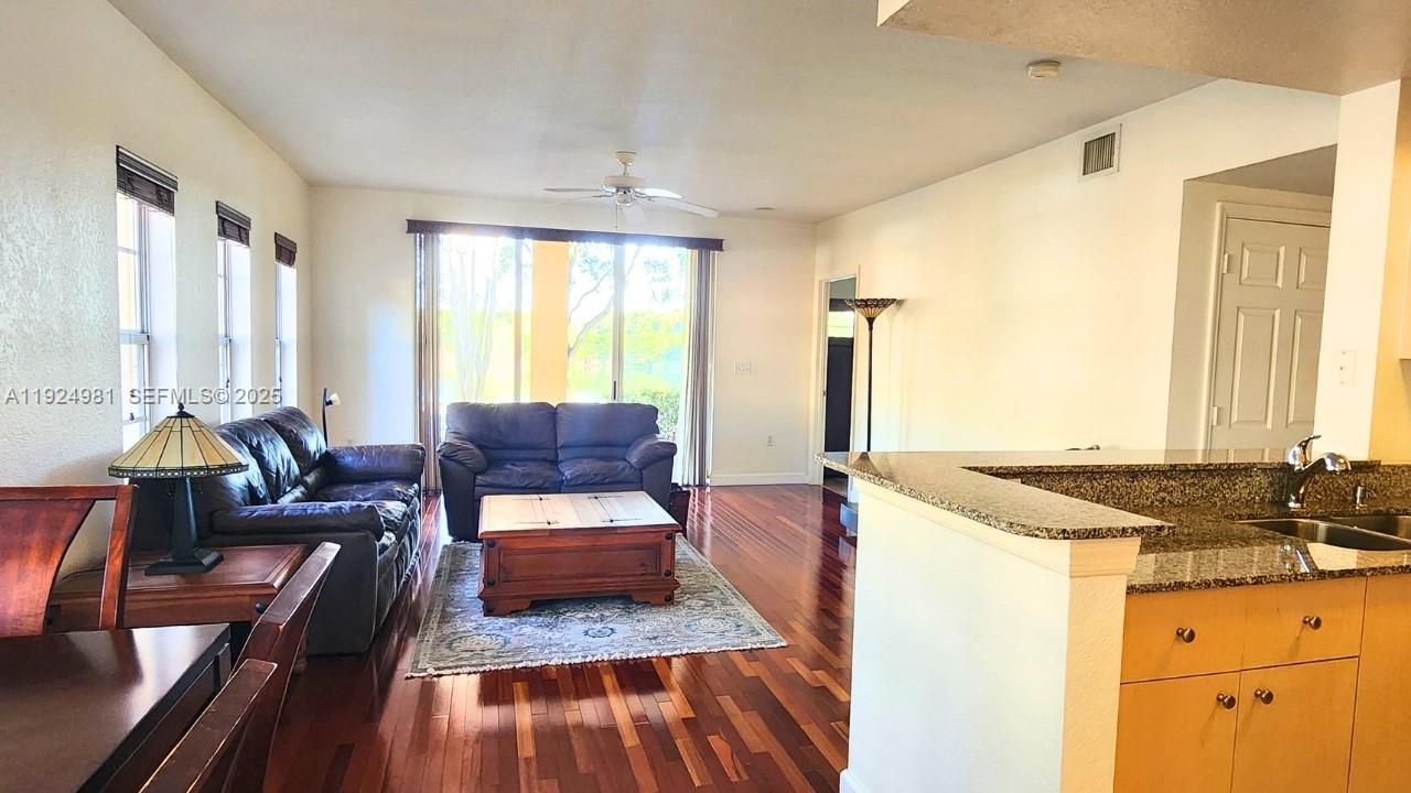 2557 Centergate Drive, Unit 101 Miramar, FL 33025 - Photo 7 of 14 a living room with furniture and a chandelier