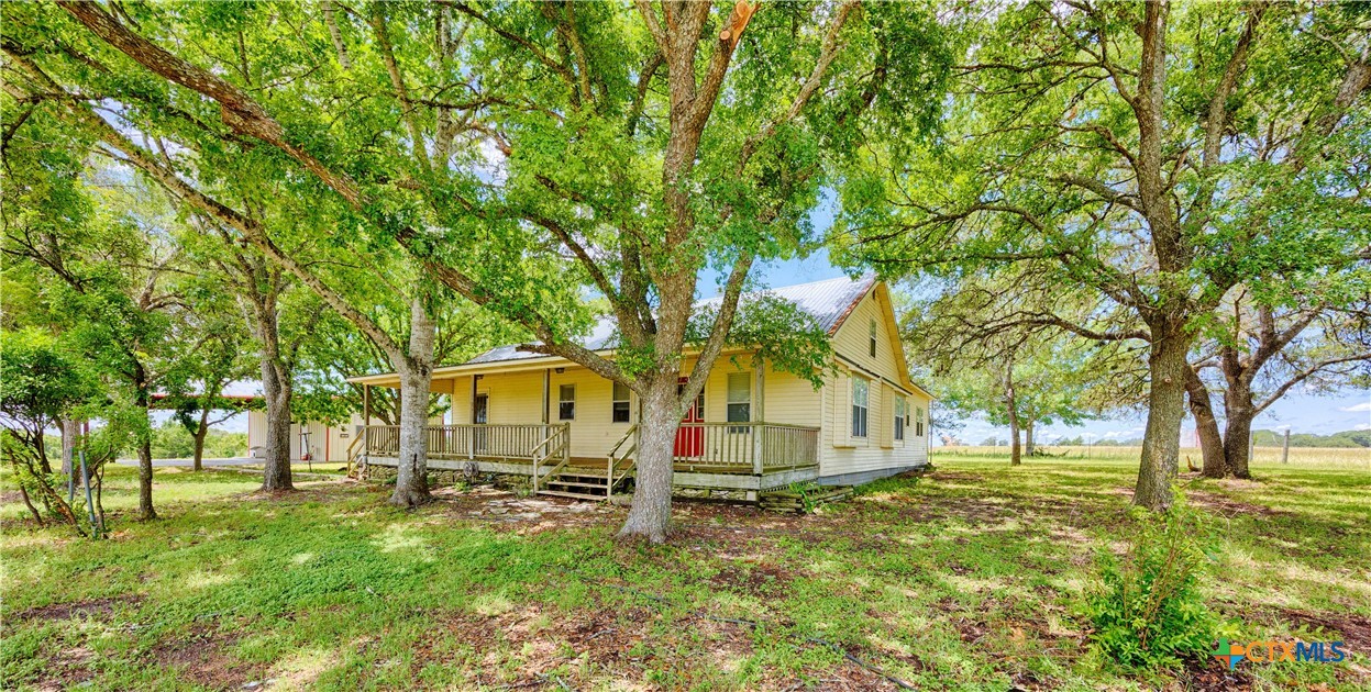 a view of backyard of house with green space