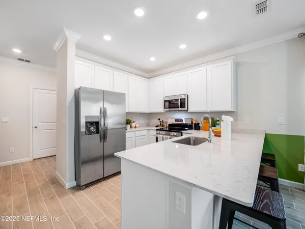a kitchen with granite countertop a sink stainless steel appliances and cabinets