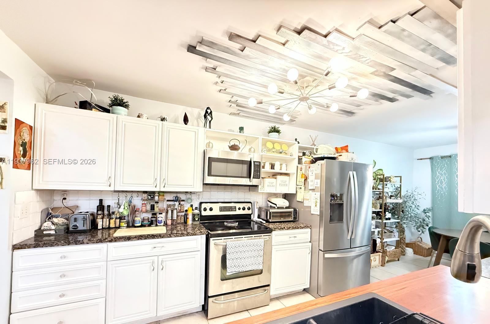 3330 Atlanta Street, Unit 14C Hollywood, FL 33021 - Photo 1 of 15 a kitchen with stainless steel appliances kitchen island granite countertop a refrigerator and a stove top oven