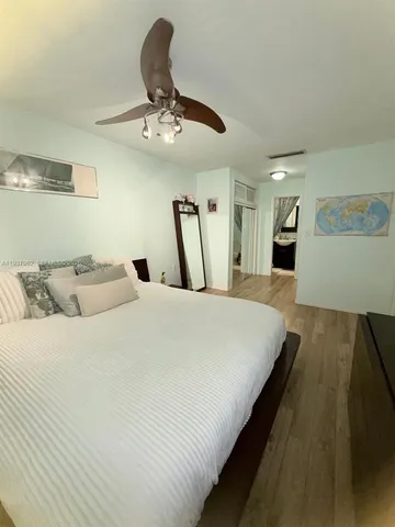 a large bed sitting in a bedroom and chandelier