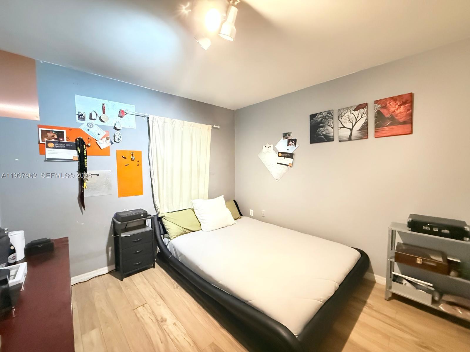 3330 Atlanta Street, Unit 14C Hollywood, FL 33021 - Photo 12 of 15 a bedroom with a bed and wooden floor