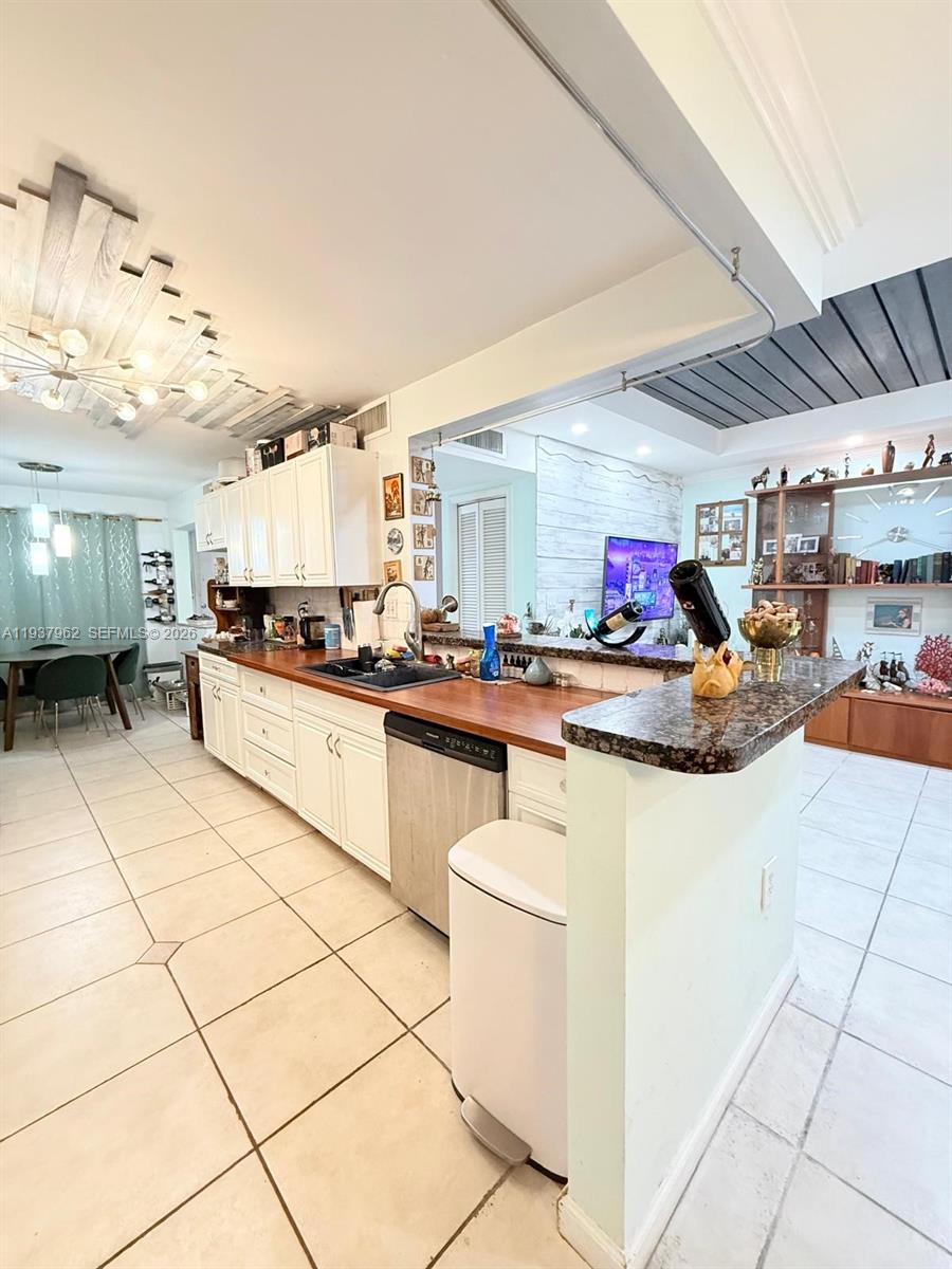 3330 Atlanta Street, Unit 14C Hollywood, FL 33021 - Photo 14 of 15 a kitchen with stainless steel appliances kitchen island granite countertop a stove a sink and a refrigerator