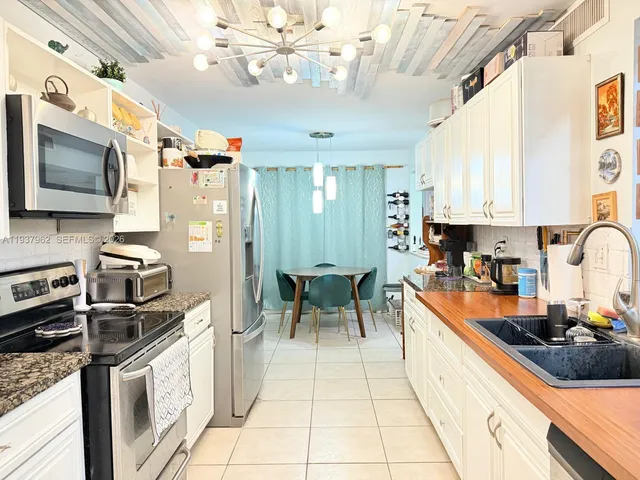 a kitchen with stainless steel appliances granite countertop a sink dishwasher stove and refrigerator