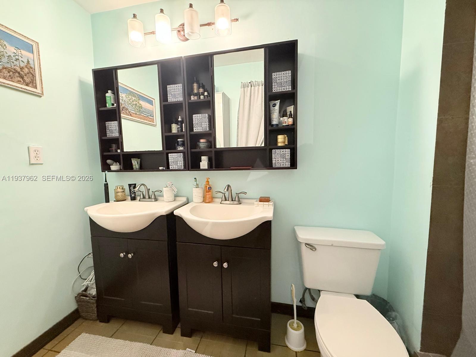 3330 Atlanta Street, Unit 14C Hollywood, FL 33021 - Photo 7 of 15 a bathroom with a toilet sink and mirror