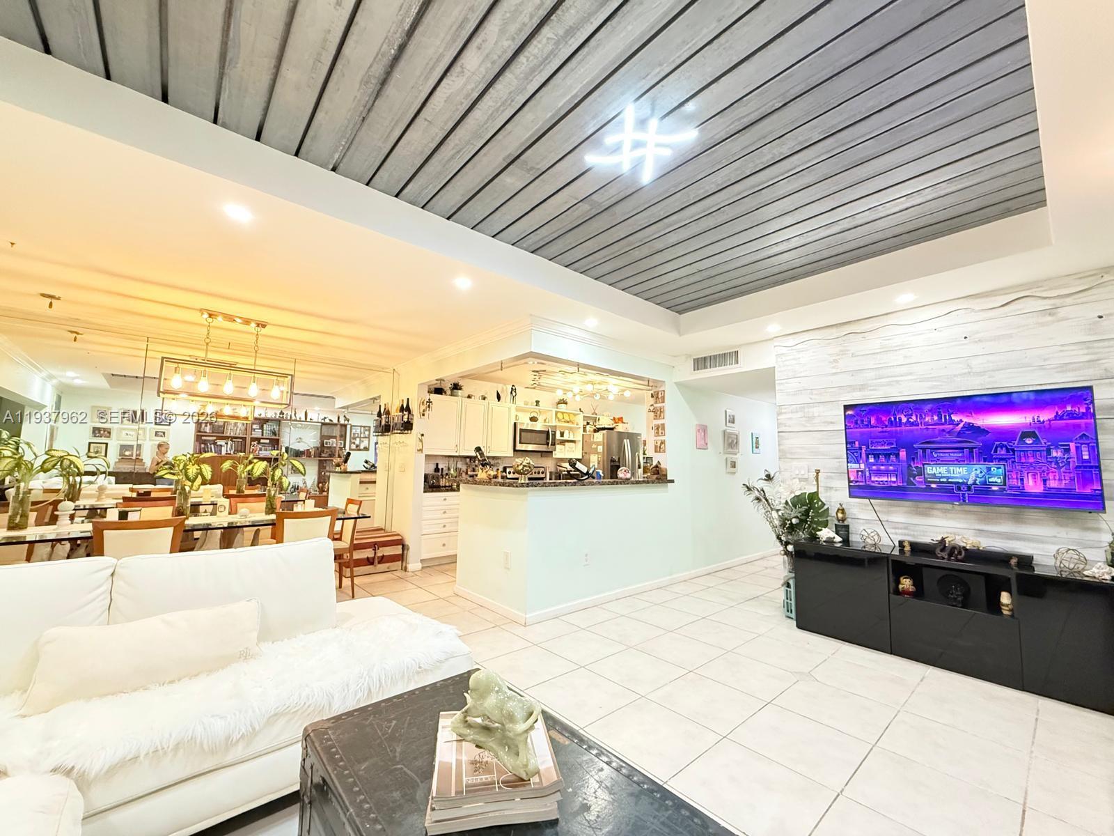 3330 Atlanta Street, Unit 14C Hollywood, FL 33021 - Photo 9 of 15 a living room with granite countertop furniture and a kitchen view