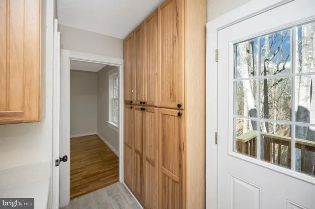 a view of a hallway with wooden floor and entryway