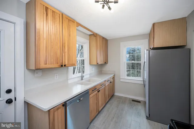 a kitchen with granite countertop a sink a counter space and cabinets