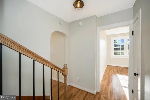 a view of a hallway with wooden floor and staircase