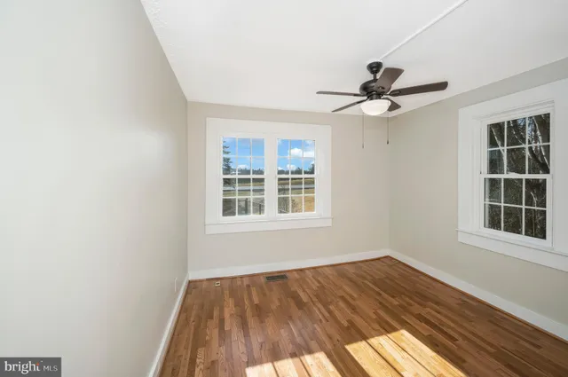 a view of a big room with wooden floor and a chandelier fan