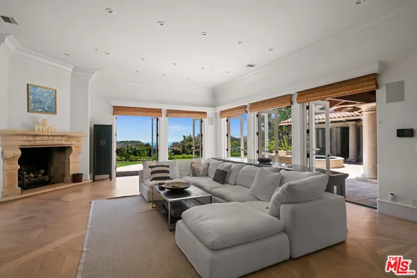 a living room with furniture large window and a fireplace