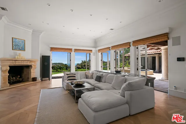 a living room with furniture large window and a fireplace