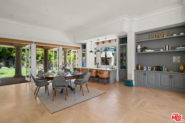a dining hall with stainless steel appliances kitchen island a table and chairs