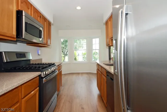 a kitchen with stainless steel appliances granite countertop a stove and a refrigerator