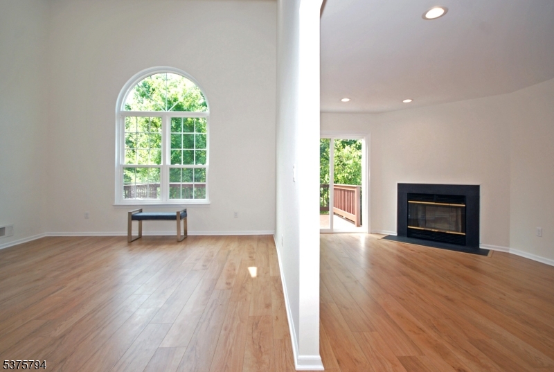 23 Buffalo Hollow Road Somerville, NJ 08876 - Photo 2 of 12 an empty room with windows a fireplace and wooden floor