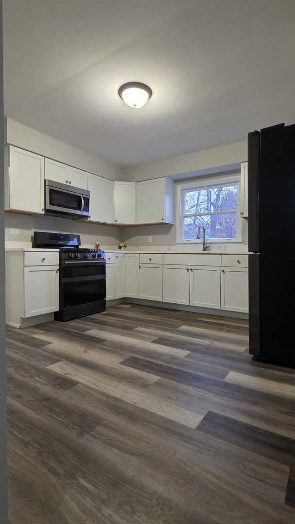 310 Pine Street Joliet, IL 60435 - Photo 15 of 20 a kitchen with a refrigerator stove and wooden cabinets
