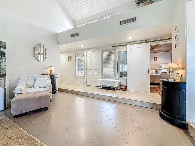 a living room with furniture and a kitchen appliance view