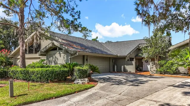 a view of a house with a yard and potted plants