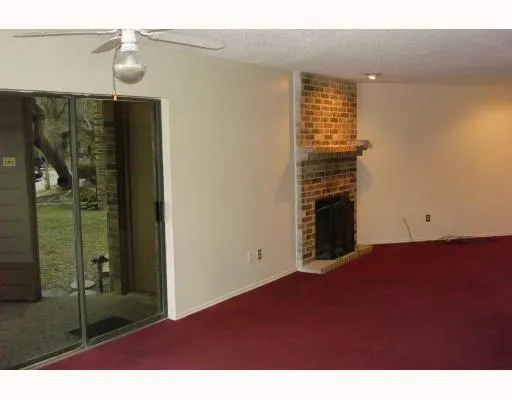 a view of empty room with floor to ceiling window and ceiling fan