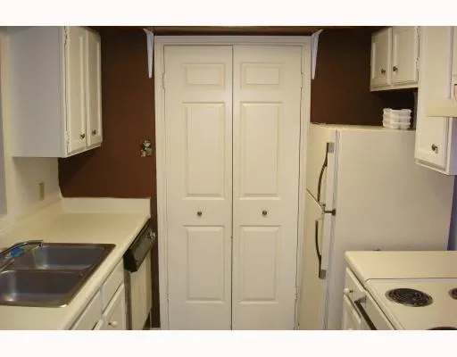 a kitchen view white cabinets and black appliances