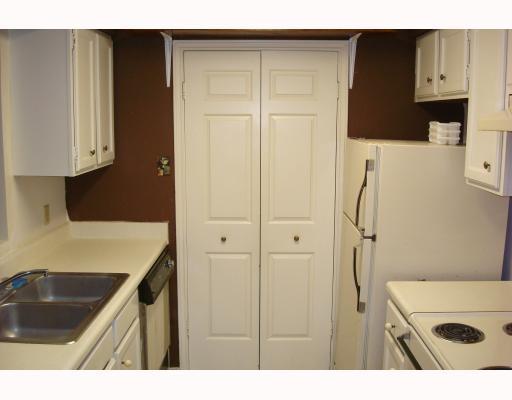 7122 Premont Drive, Unit 101F Corpus Christi, TX 78414 - Photo 5 of 8 a kitchen view white cabinets and black appliances