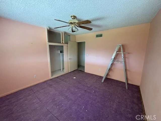 an empty room with a ceiling fan and entryway