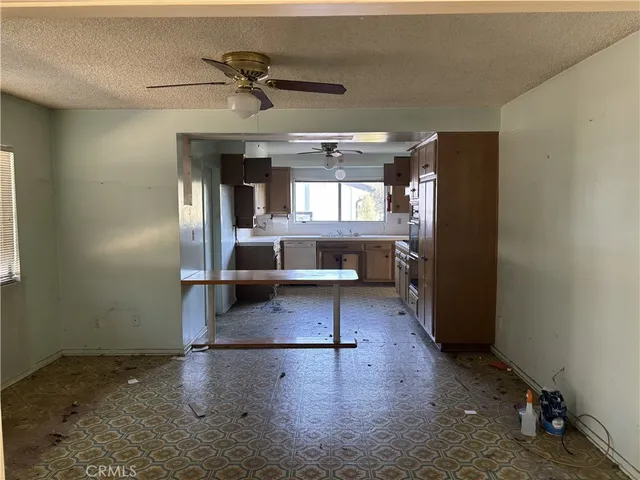 a view of a room with kitchen island stainless steel appliances wooden floor and view living room