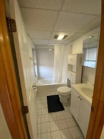a bathroom with a sink a toilet a mirror and shower
