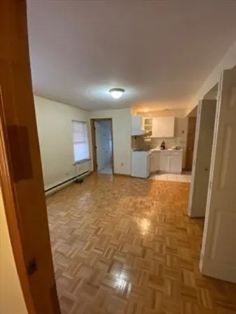 a view of kitchen and empty room with windows