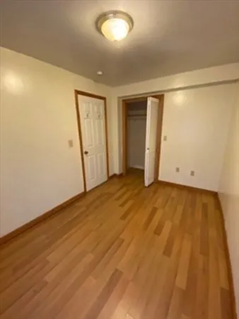 an empty room with wooden floor and white walls
