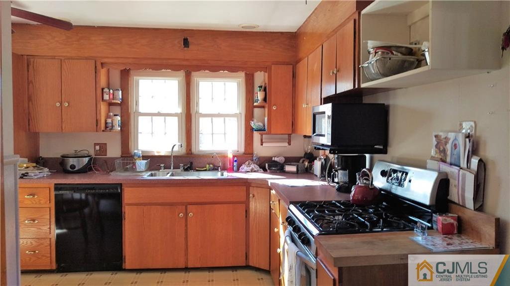 333 Amboy Road Old Bridge, NJ 07747 - Photo 3 of 17 a kitchen with a stove a sink and a microwave