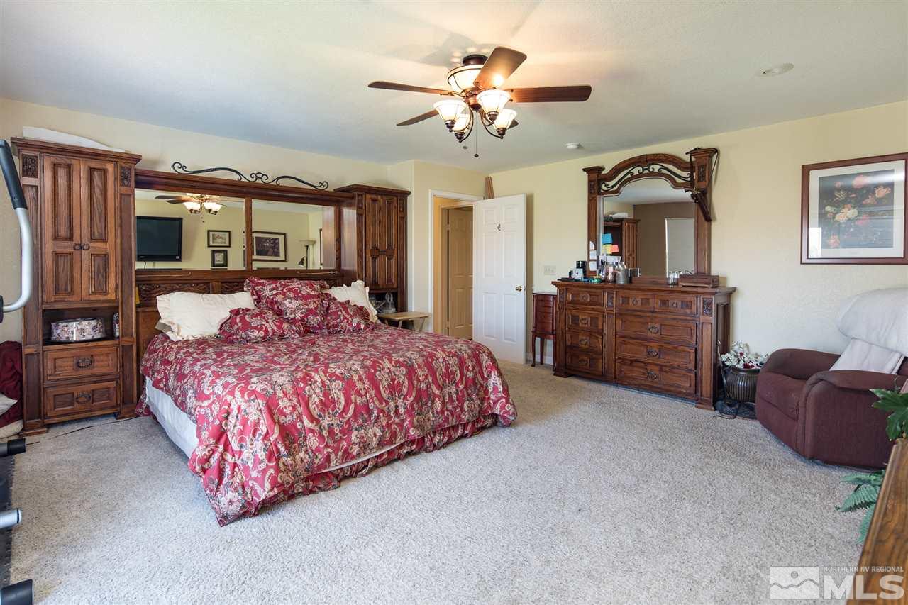 10385 Placerville Road Reno, NV 89508 - Photo 15 of 25 a bedroom with a large bed and a chandelier