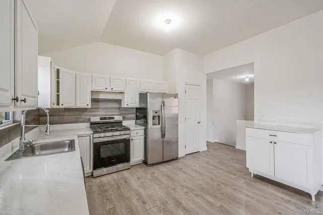 a kitchen with stainless steel appliances a stove a sink and a refrigerator