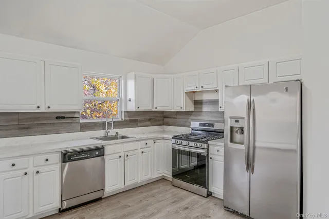 a kitchen with a white stove refrigerator and cabinets