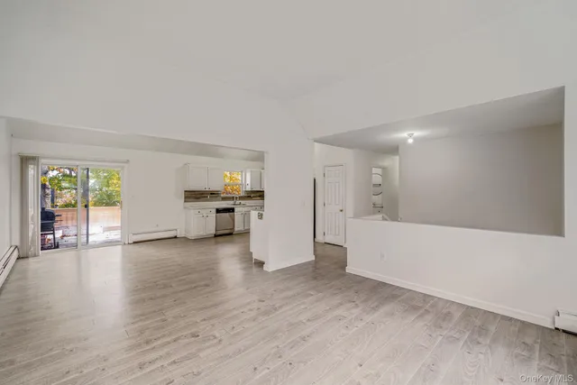 a view of empty room with wooden floor and window