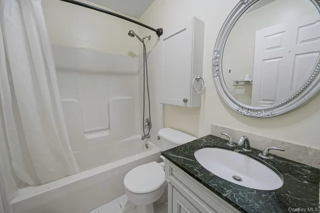 a bathroom with a granite countertop sink toilet a mirror and shower