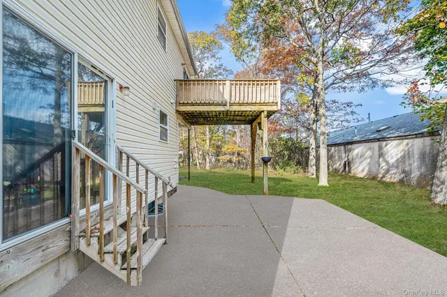 a view of a house with a small yard and a large tree