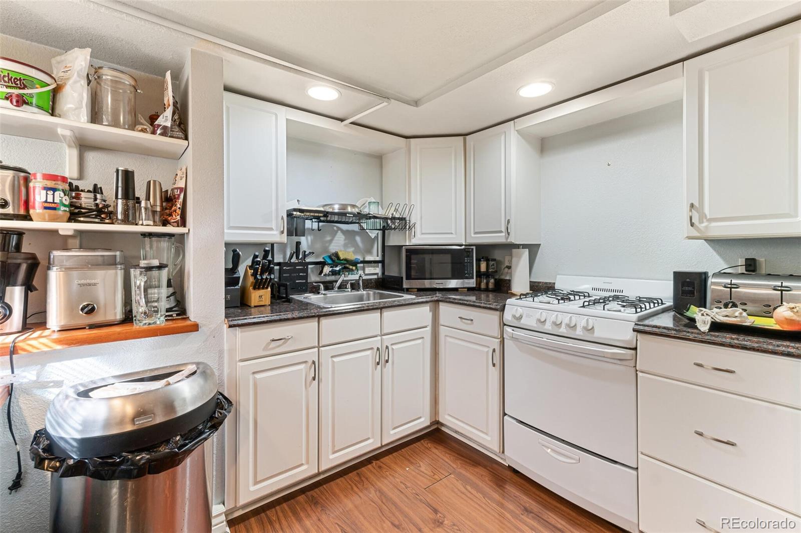 2089 South Logan Street Denver, CO 80210 - Photo 31 of 41 a kitchen with stainless steel appliances granite countertop a sink a stove and cabinets