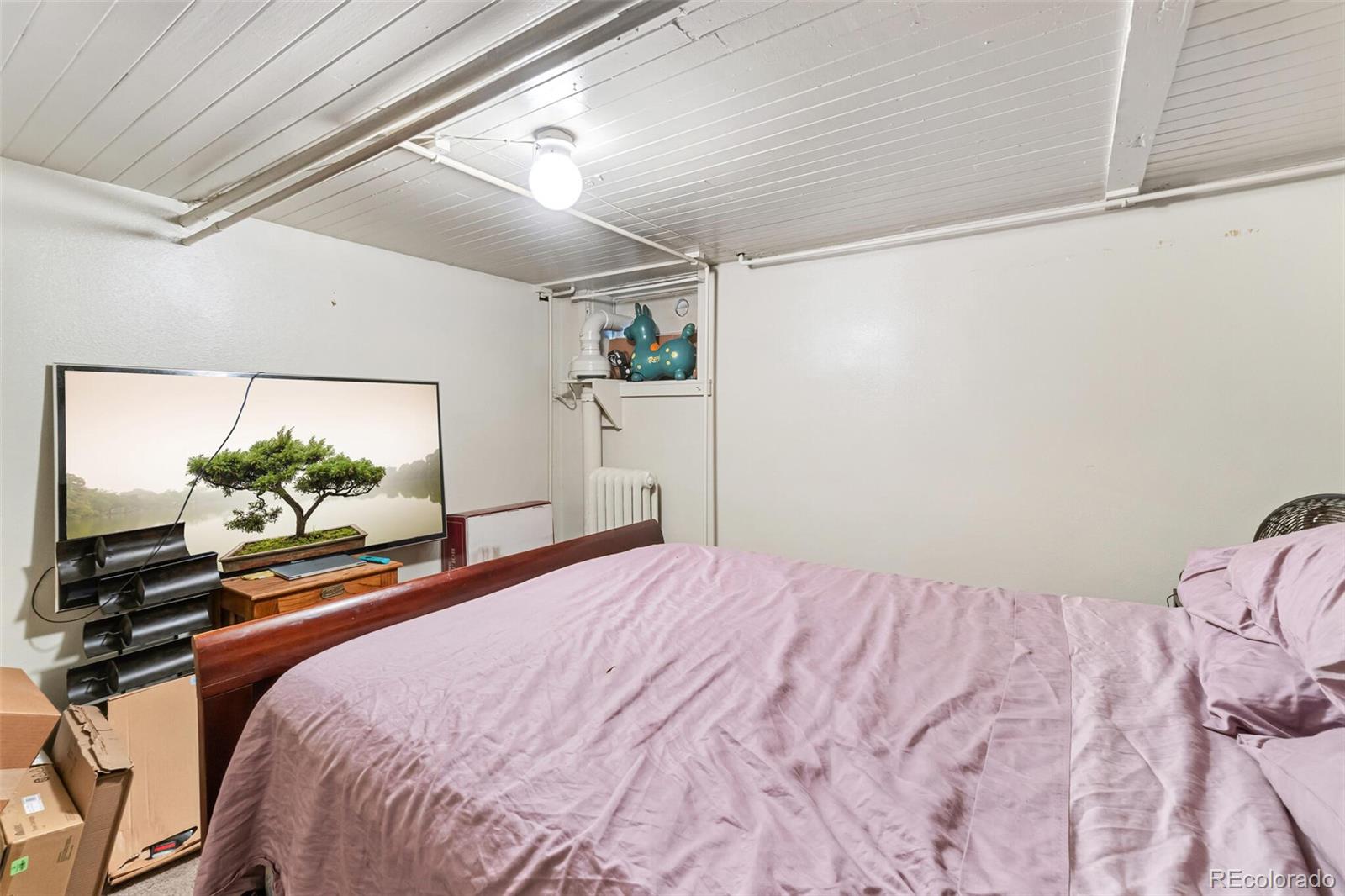 2089 South Logan Street Denver, CO 80210 - Photo 32 of 41 a bedroom with a bed and a flat screen tv