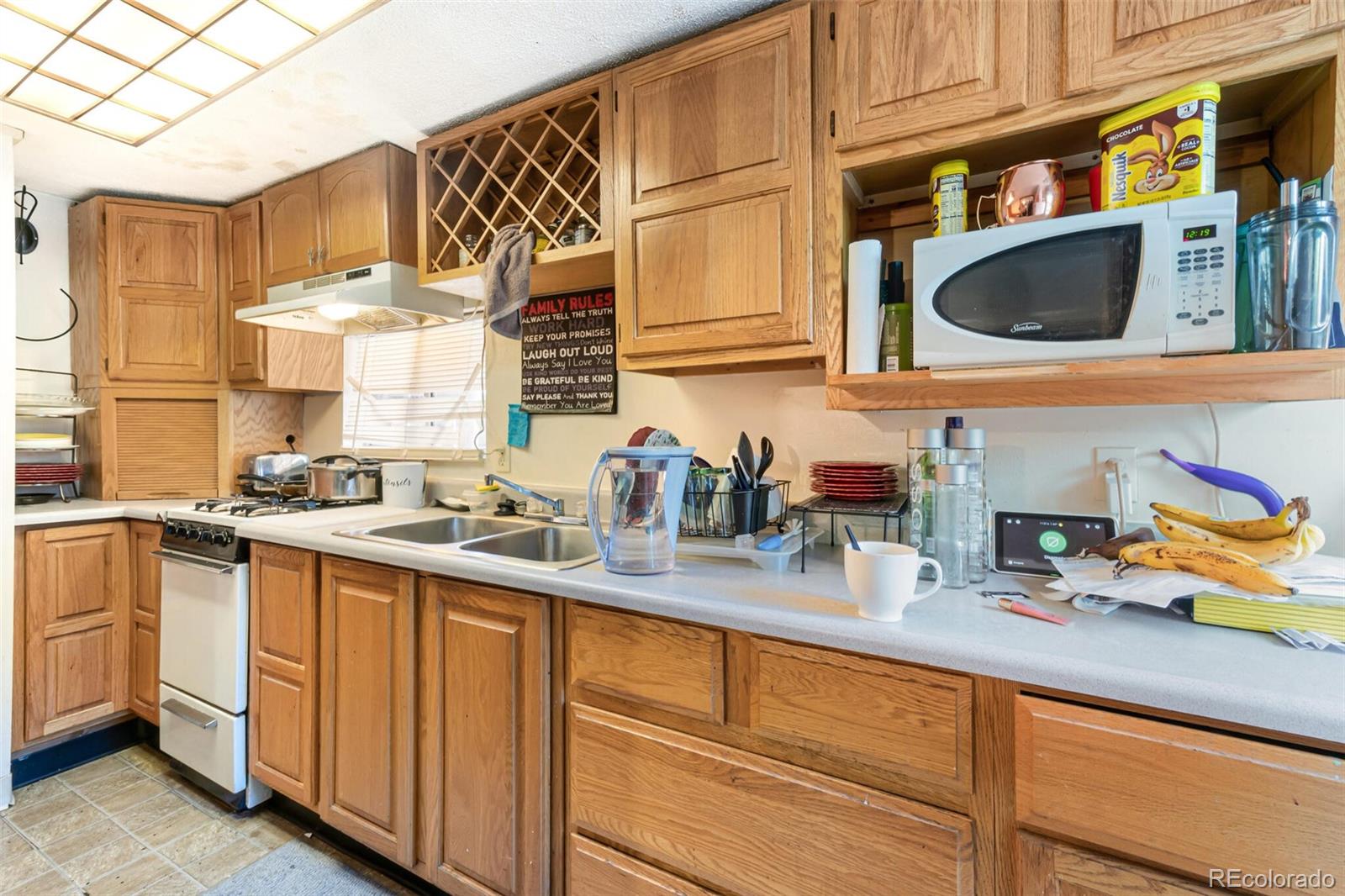 2089 South Logan Street Denver, CO 80210 - Photo 35 of 41 a kitchen with stainless steel appliances granite countertop a sink and a microwave