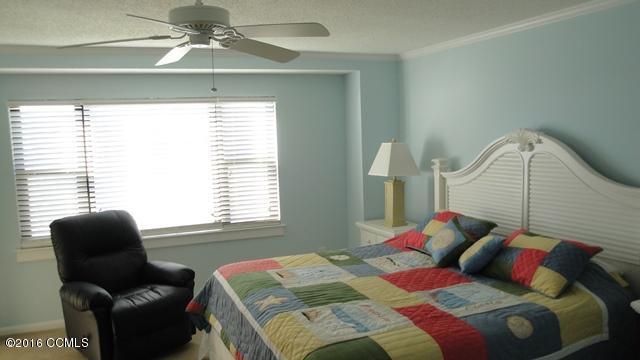 1505 Salter Path Road, Unit 420 Indian Beach, NC 28512 - Photo 13 of 15 Principal bedroom with window facing pool/ocean & walk out to deck.