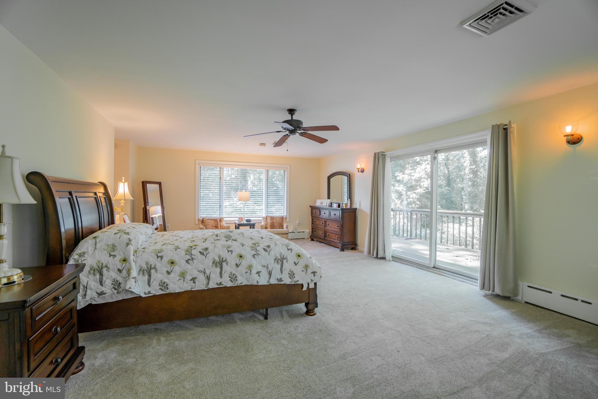 285 Shoemaker Road Huntingdon Valley, PA 19006 - Photo 14 of 46 a spacious bedroom with a large bed and a chandelier