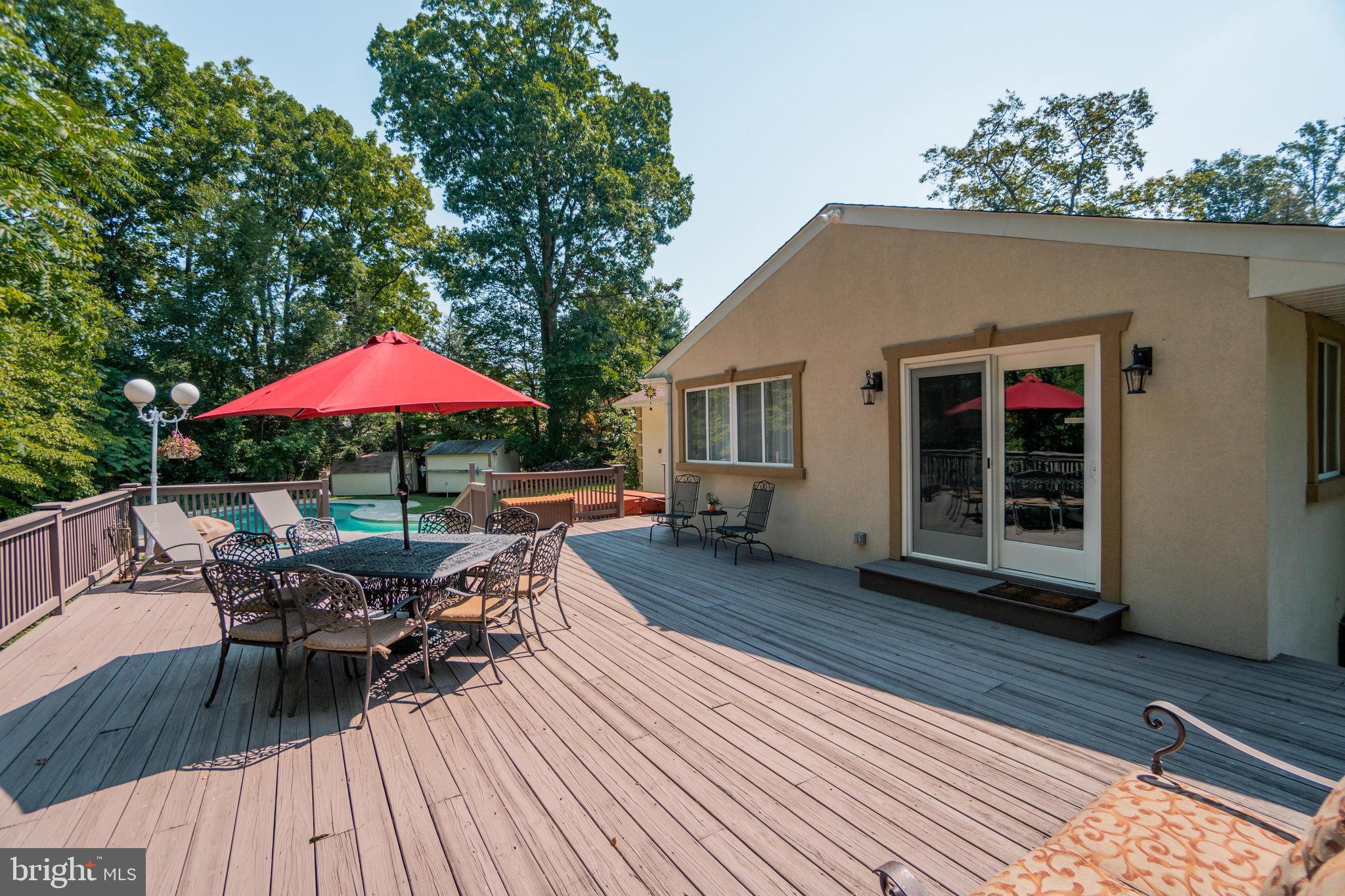 285 Shoemaker Road Huntingdon Valley, PA 19006 - Photo 40 of 46 a view of a deck with table and chairs under an umbrella with wooden floor