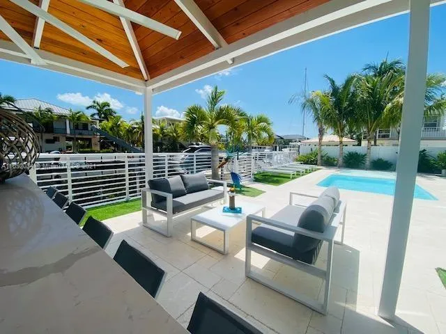 a view of a patio with couches chairs potted plants and palm trees