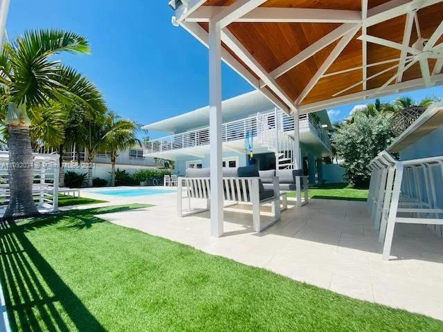 a patio with table and chairs and potted plants