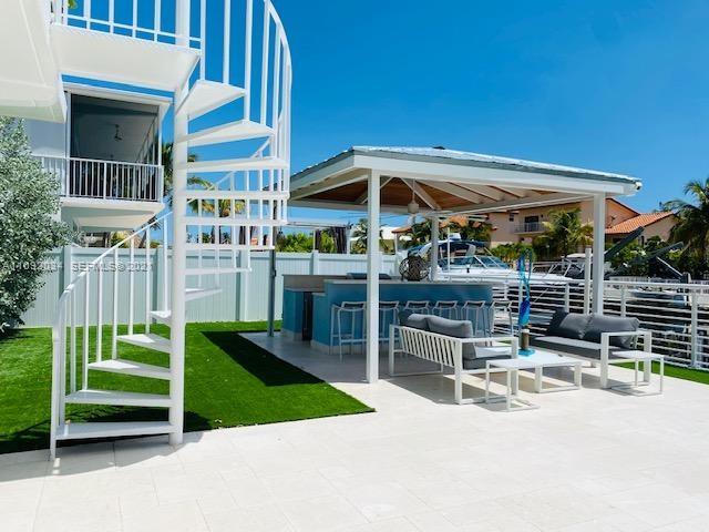 203 Atlantic Boulevard, Unit 203 Key Largo, FL 33037 - Photo 18 of 41 a view of a chairs and table in backyard of the house