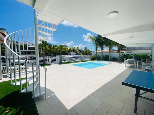 203 Atlantic Boulevard, Unit 203 Key Largo, FL 33037 - Photo 23 of 41 a swimming pool with outdoor seating and yard