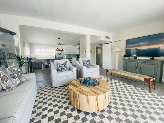 203 Atlantic Boulevard, Unit 203 Key Largo, FL 33037 - Photo 26 of 41 a living room with furniture and a dining table with wooden floor