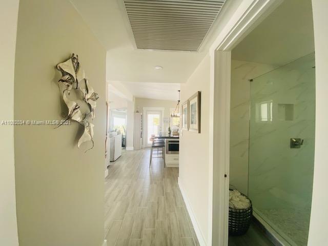203 Atlantic Boulevard, Unit 203 Key Largo, FL 33037 - Photo 29 of 41 a view of a hallway with wooden floor and a bathroom